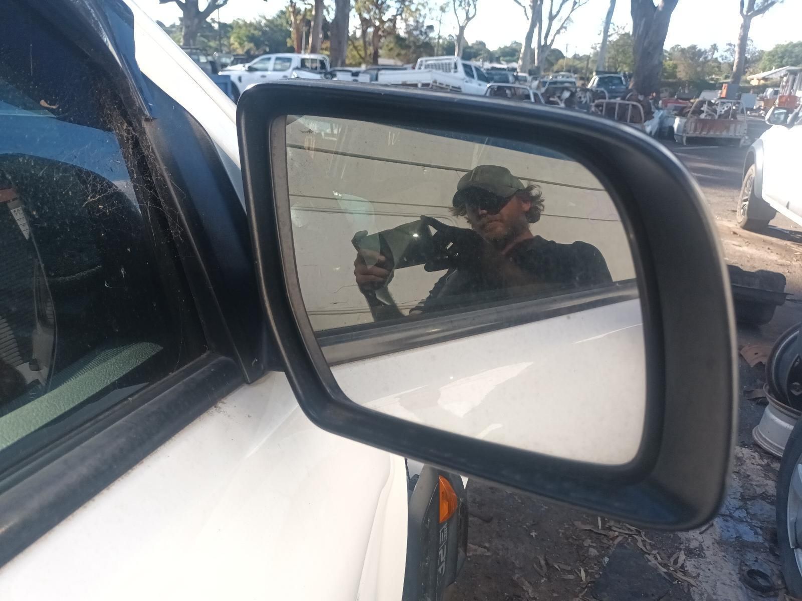 A Man is Taking a Picture of Himself in the Side Mirror of a Car — South West 4WD Wreckers in Harristown, QLD