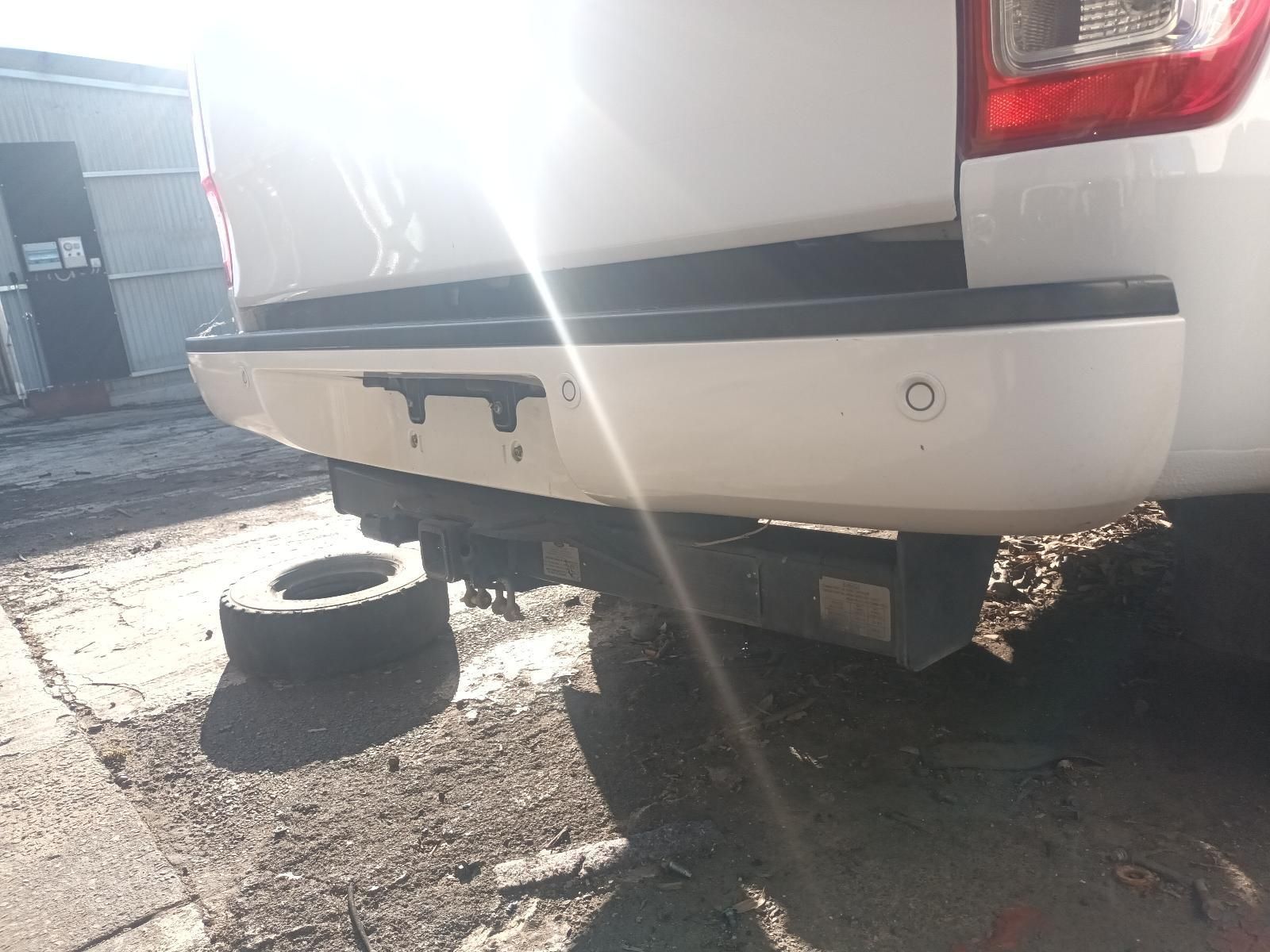 A White Truck is Parked on the Side of the Road Next to a Tire — South West 4WD Wreckers in Harristown, QLD