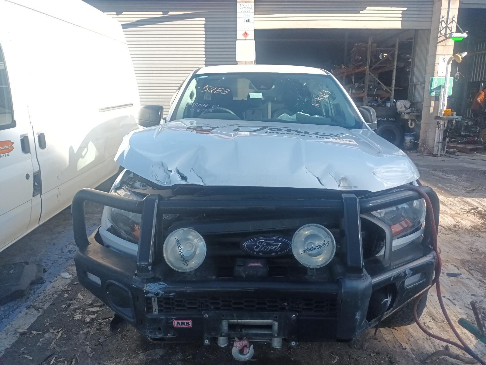 A White Truck with a Black Bumper is Parked in Front of a Garage — South West 4WD Wreckers in Harristown, QLD