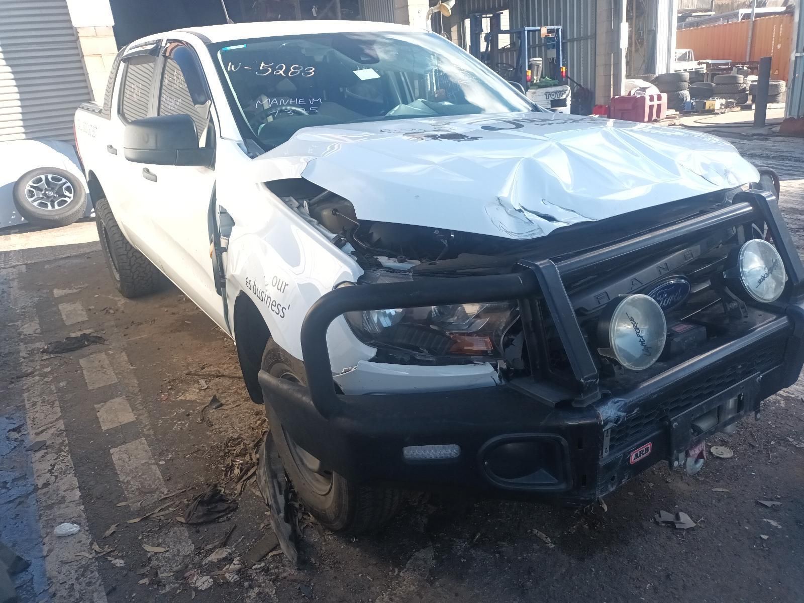 A White Truck with a Black Bumper is Parked in Front of a Garage — South West 4WD Wreckers in Harristown, QLD