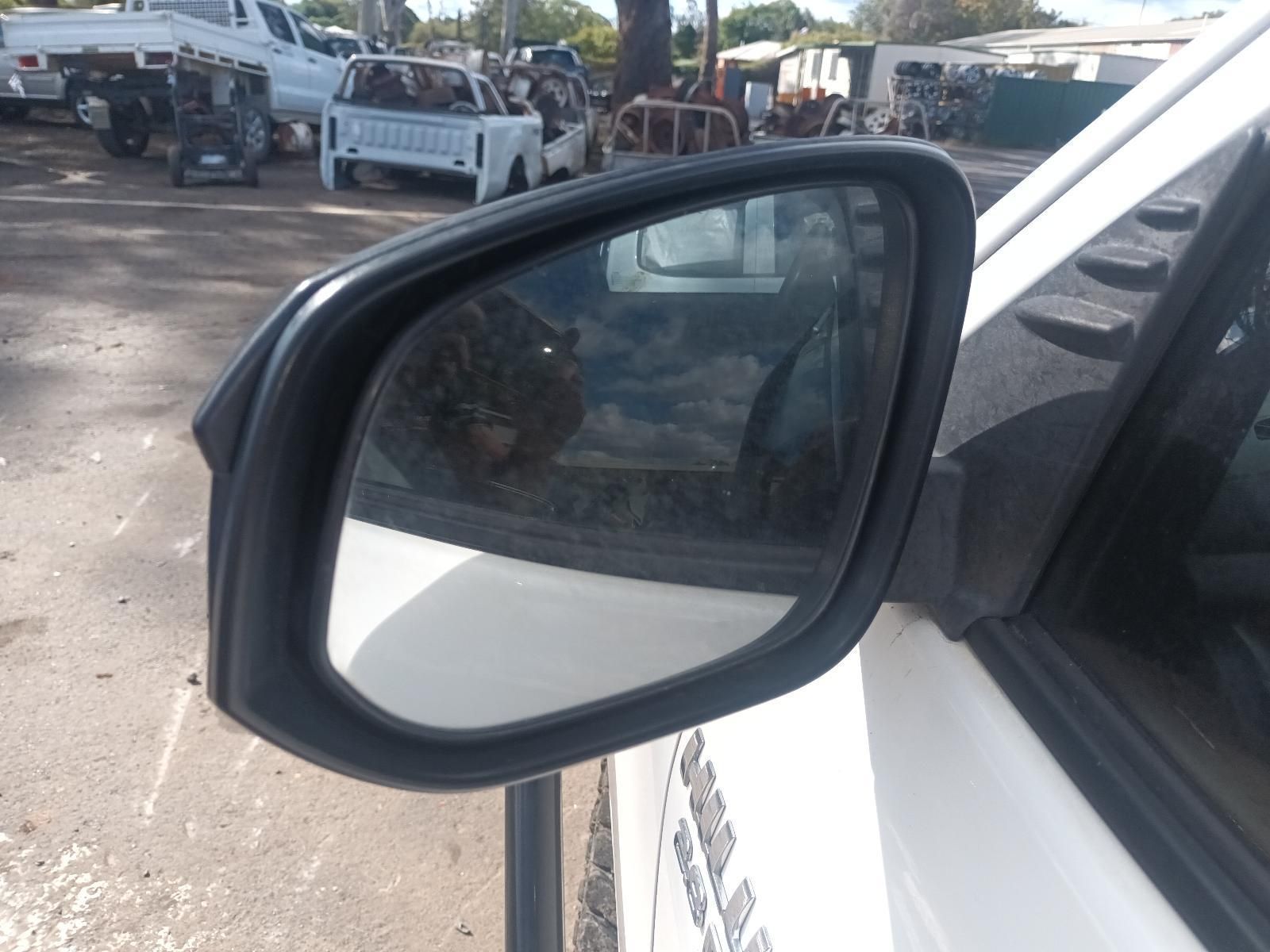 A Side View Mirror on a White Car with a Truck in the Background — South West 4WD Wreckers in Harristown, QLD