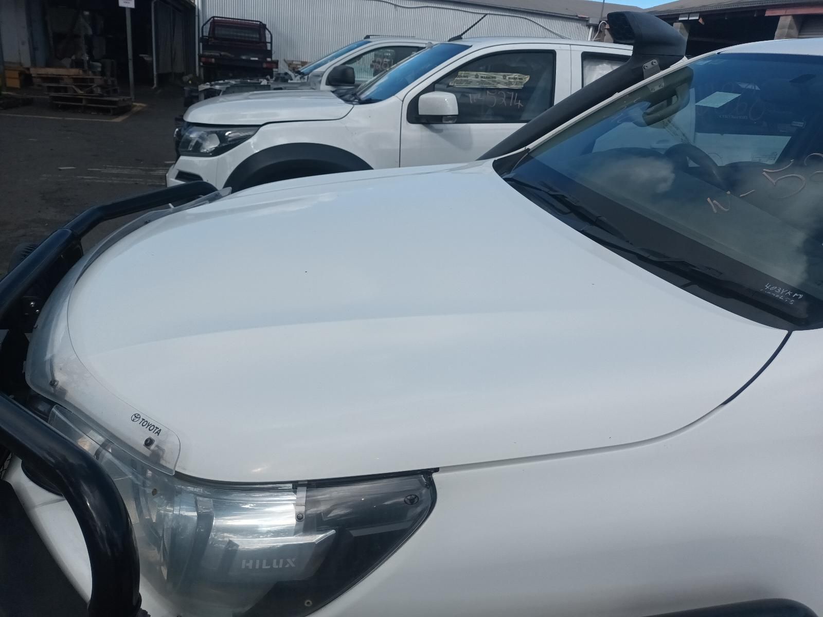 A Row of White Trucks Are Parked in a Parking Lot — South West 4WD Wreckers in Harristown, QLD 