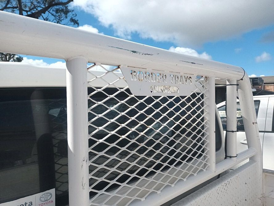 A White Truck with a Mesh Grille on the Back of It — South West 4WD Wreckers in Harristown, QLD