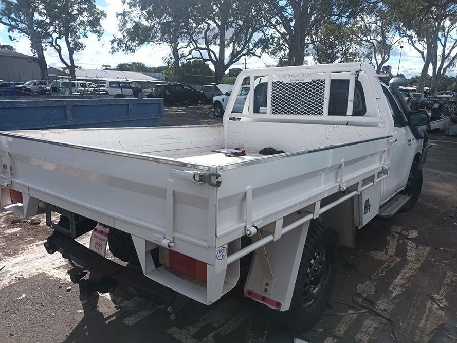 A White Truck with a Flat Bed is Parked in a Parking Lot — South West 4WD Wreckers in Harristown, QLD