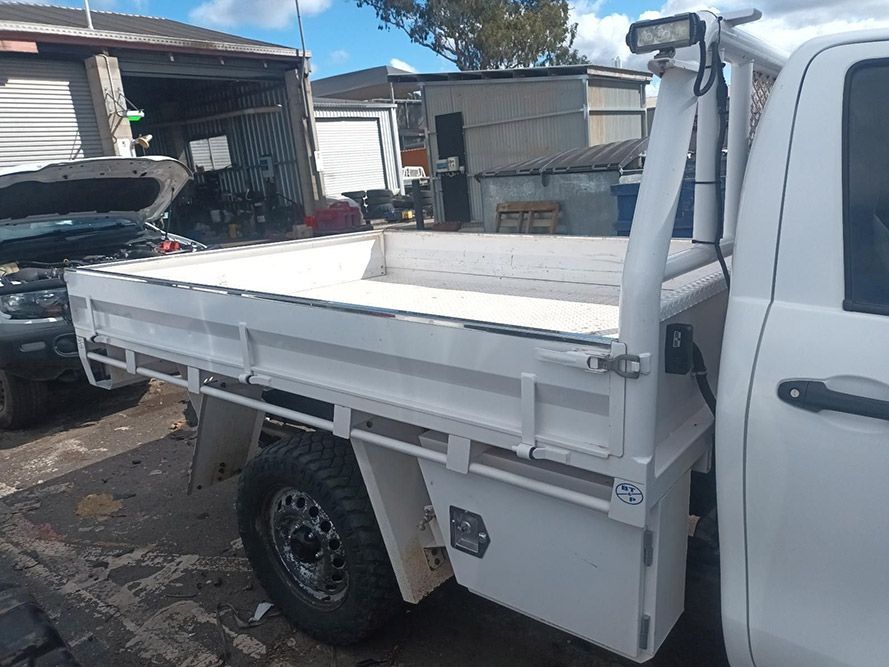 A White Truck with a Flat Bed is Parked in a Parking Lot — South West 4WD Wreckers in Harristown, QLD