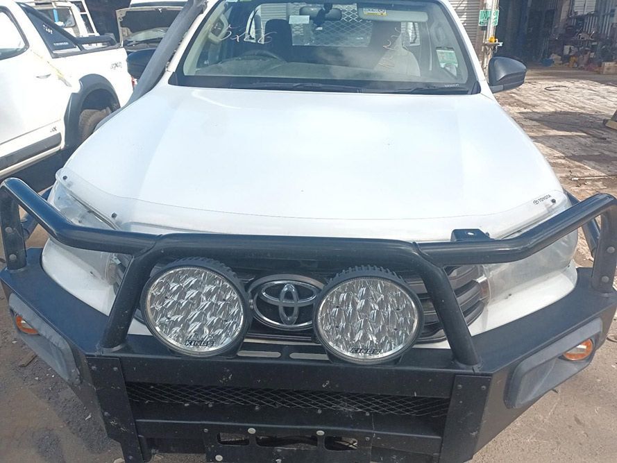 A White Toyota Hilux with a Black Bumper is Parked on the Side of the Road — South West 4WD Wreckers in Harristown, QLD