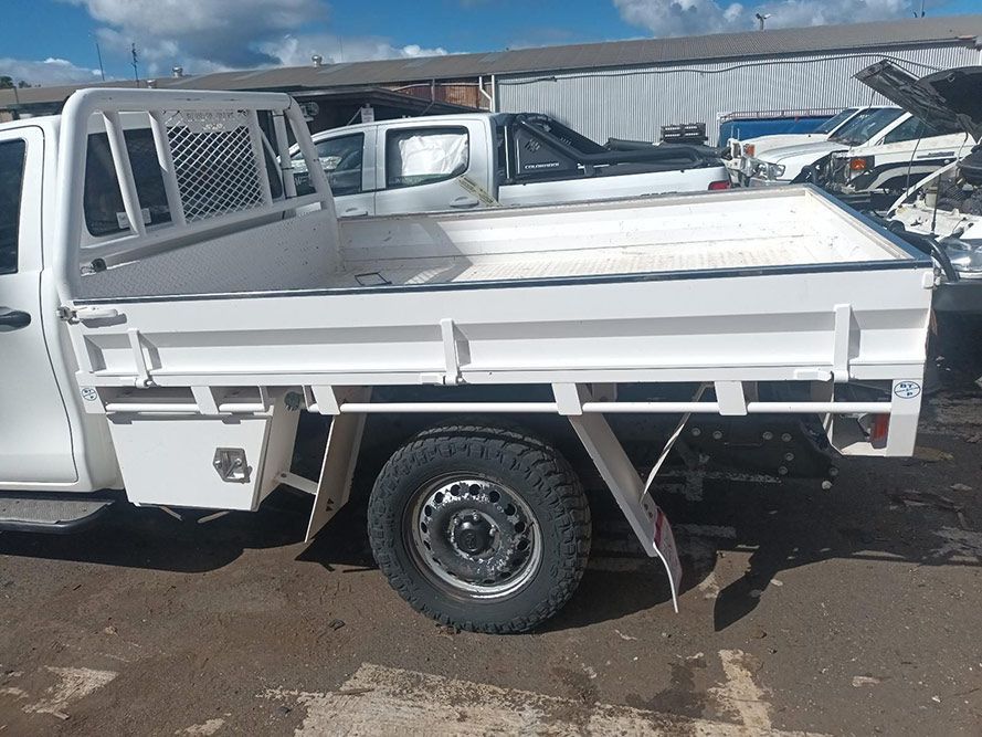 A White Truck with a Flat Bed is Parked in a Parking Lot — South West 4WD Wreckers in Harristown, QLD