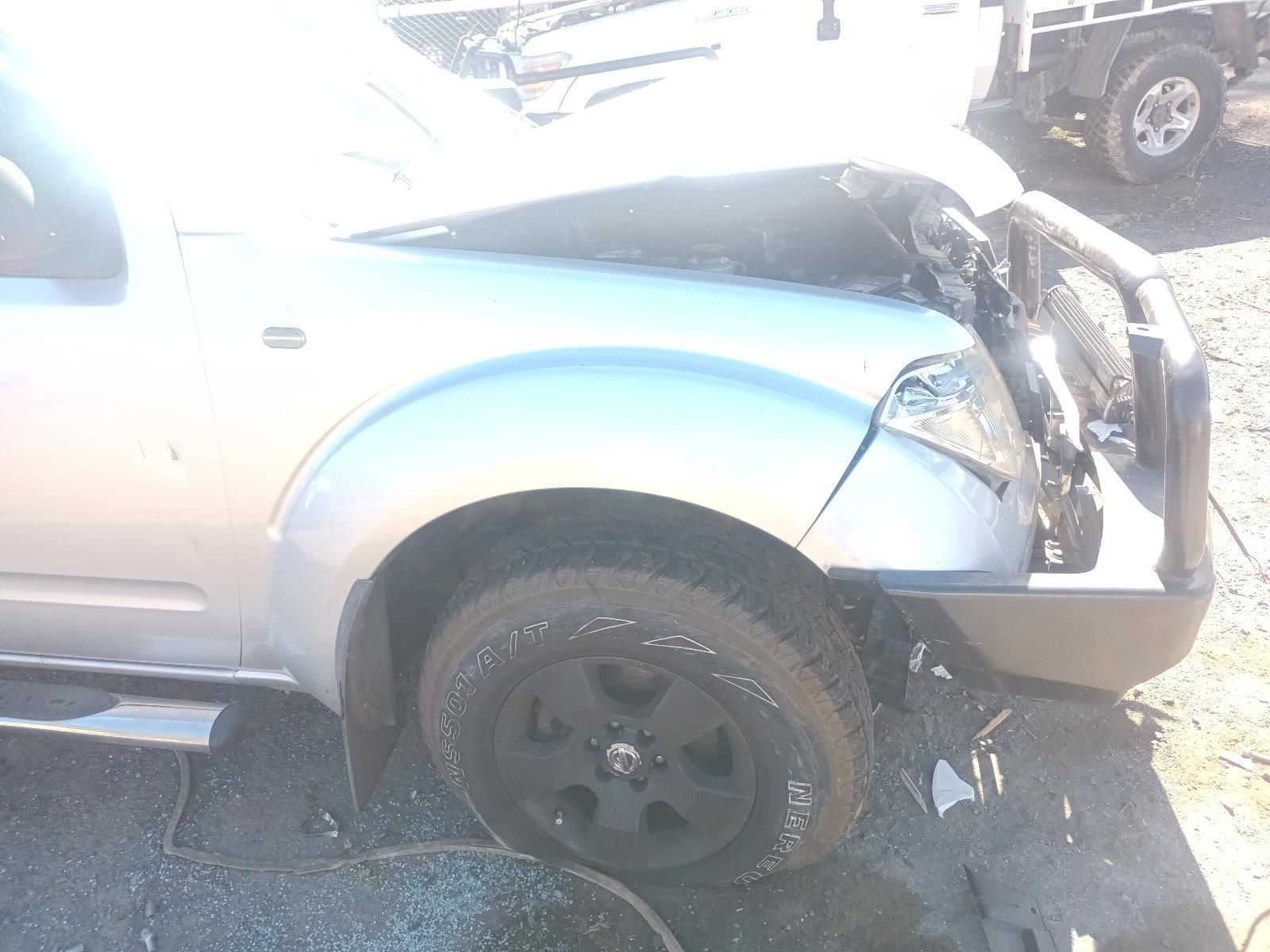 A Silver Car with a Broken Fender is Parked on the Side of the Road — South West 4WD Wreckers in Harristown, QLD