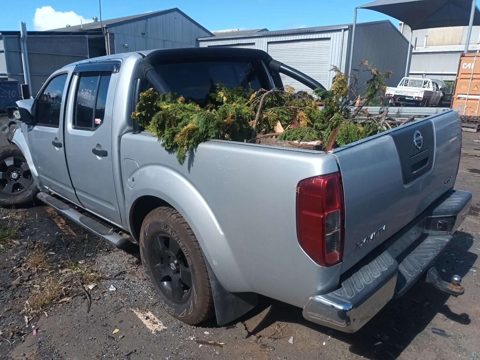 A Silver Nissan Truck is Parked in a Lot with Trees in the Bed — South West 4WD Wreckers in Harristown, QLD