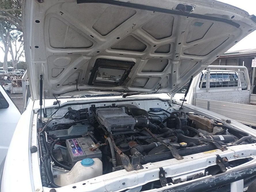 The Hood of a White Truck is Open and the Engine is Visible — South West 4WD Wreckers in Harristown, QLD