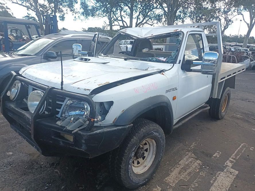 A White Truck with a Damaged Hood is Parked in a Parking Lot — South West 4WD Wreckers in Harristown, QLD