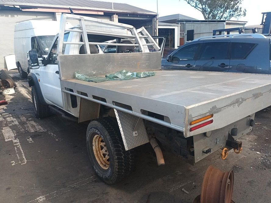 A White Truck with a Flat Bed is Parked in a Parking Lot — South West 4WD Wreckers in Harristown, QLD