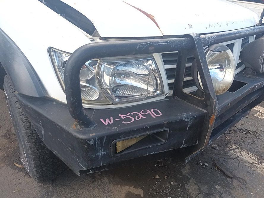 A White Truck with a Black Bumper is Parked on the Side of the Road — South West 4WD Wreckers in Harristown, QLD