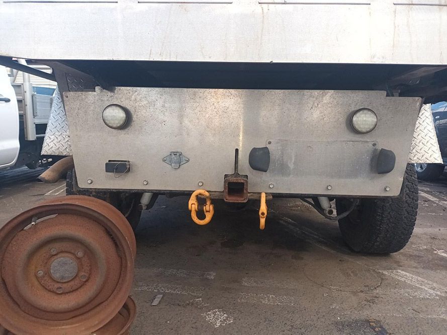 A Truck is Parked in a Parking Lot Next to a Wheel — South West 4WD Wreckers in Harristown, QLD