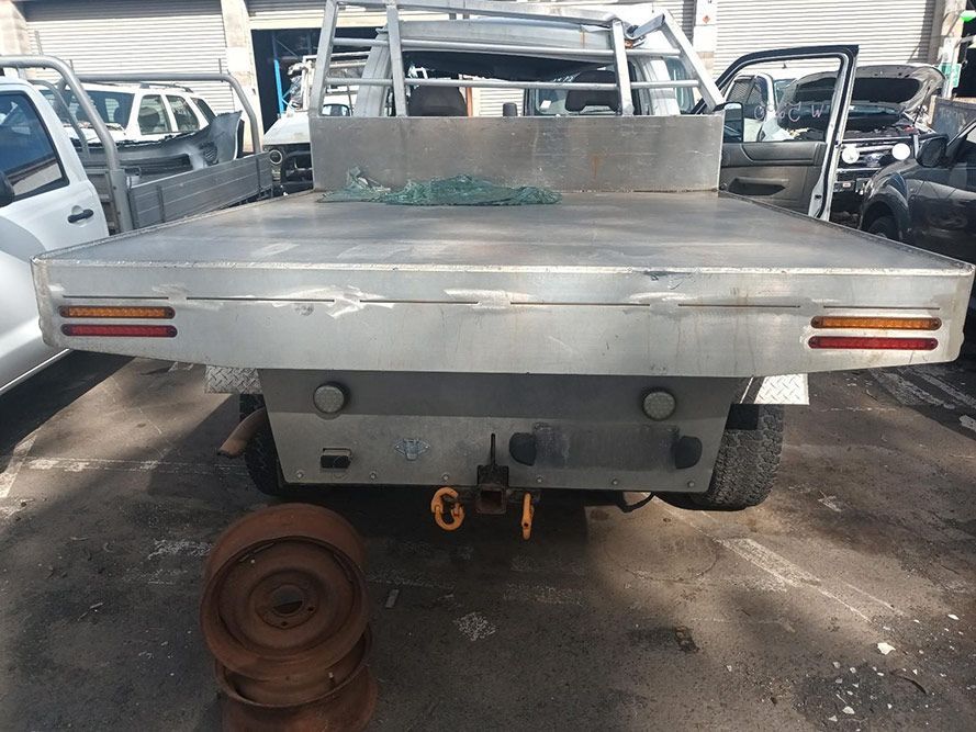 A Silver Truck with a Flat Bed is Parked in a Parking Lot — South West 4WD Wreckers in Harristown, QLD