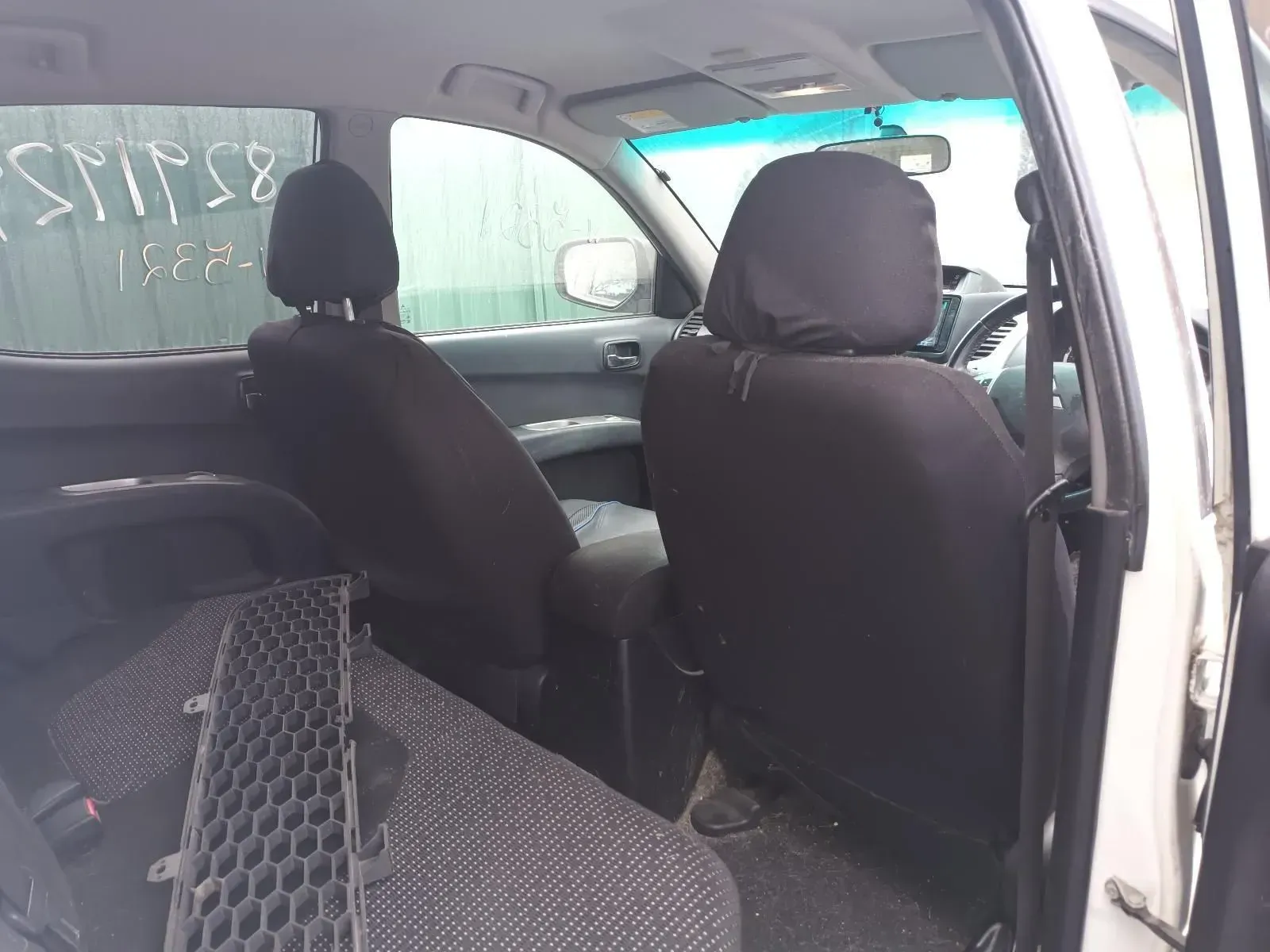 Interior of a White Car With Black Seat Covers. A Part is on the Back Seat — South West 4WD Wreckers In Brisbane, QLD