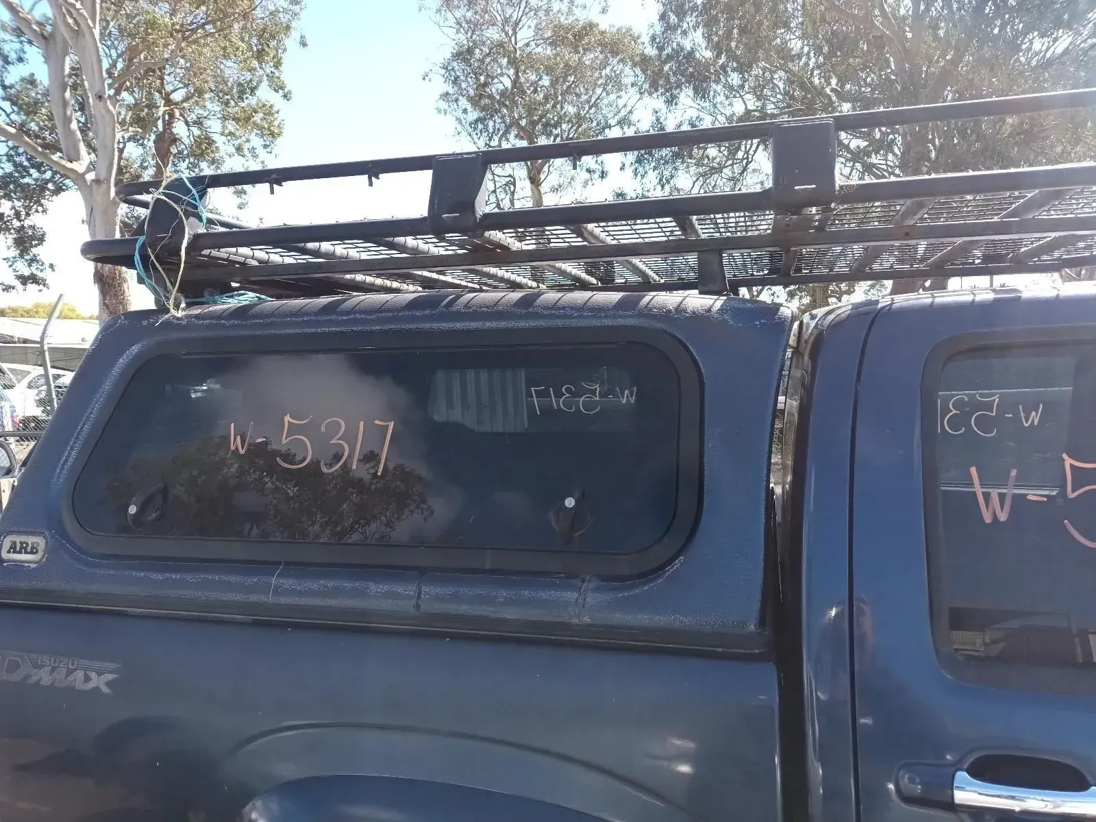 Blue Truck With a Black Camper Shell and Roof Rack, Outdoors — South West 4WD Wreckers In Brisbane, QLD