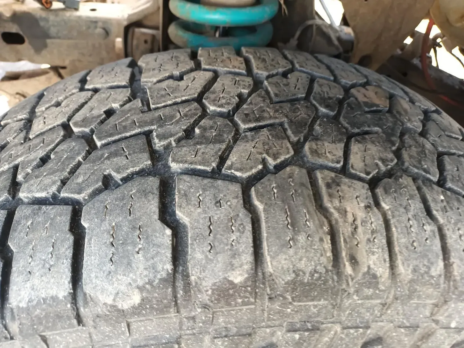 Close-up of a Worn Tyre Tread With a Teal-colored Suspension Spring — South West 4WD Wreckers In Brisbane, QLD