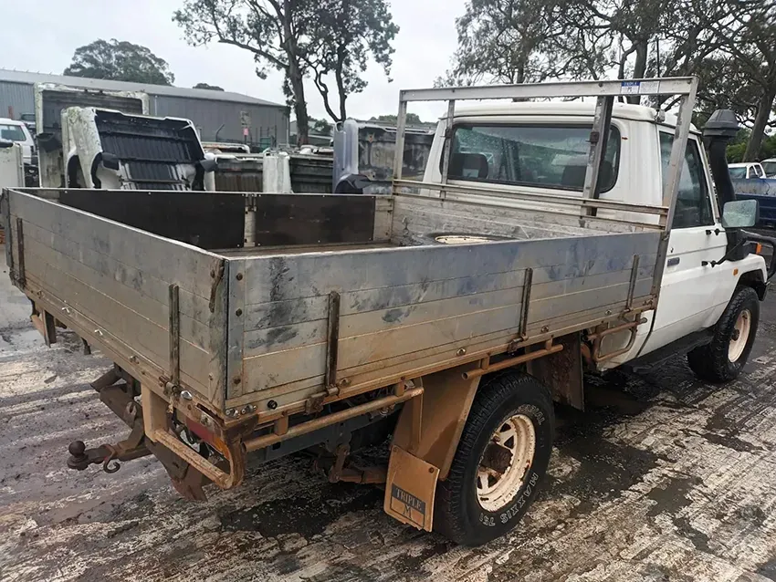 A White Truck With a Flat Bed is Parked in a Parking Lot — South West 4WD Wreckers In Brisbane, QLD