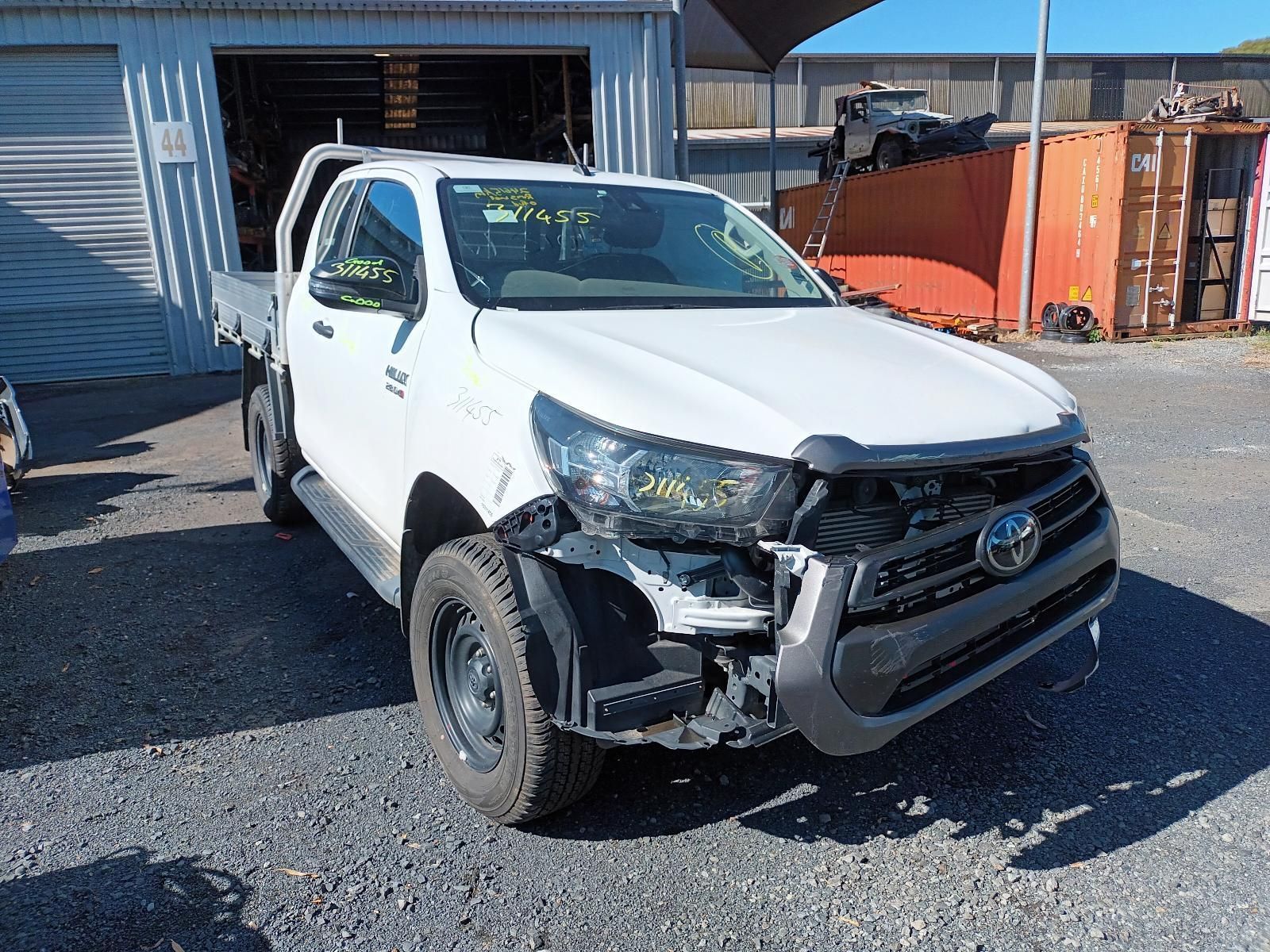 A White Truck with a Damaged Front End is Parked in Front of a Garage — South West 4WD Wreckers in Harristown, QLD