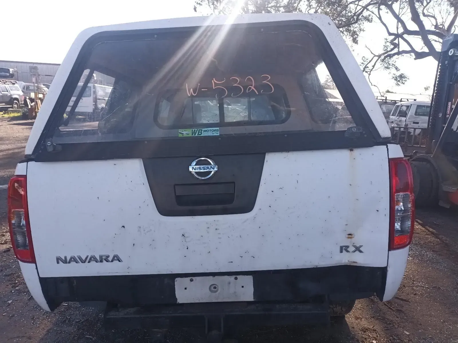 White Nissan Navara Rx Pickup Truck With a Canopy at a Salvage Yard — South West 4WD Wreckers In Brisbane, QLD