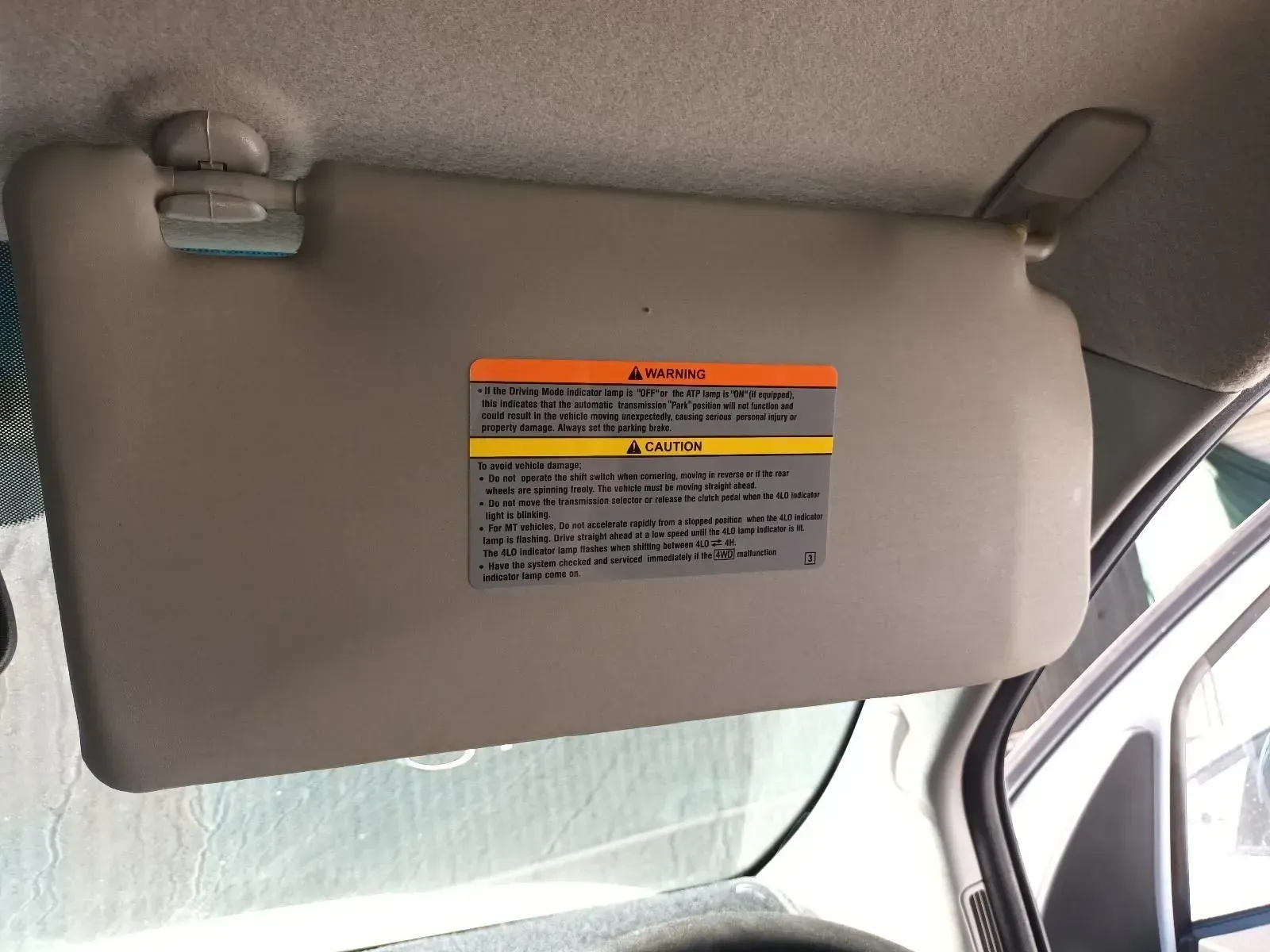 Beige Car Sun Visor With Warning Labels, Attached to a Vehicle's Ceiling — South West 4WD Wreckers In Brisbane, QLD