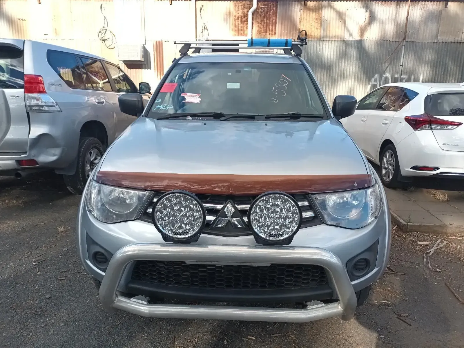 Silver Mitsubishi Triton Pickup Truck With Bull Bar and Spotlights Parked Outside — South West 4WD Wreckers In Brisbane, QLD