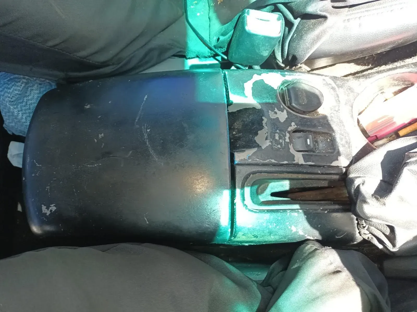 Black, Damaged Car Console With Peeling Paint, Lying on Fabric — South West 4WD Wreckers In Brisbane, QLD