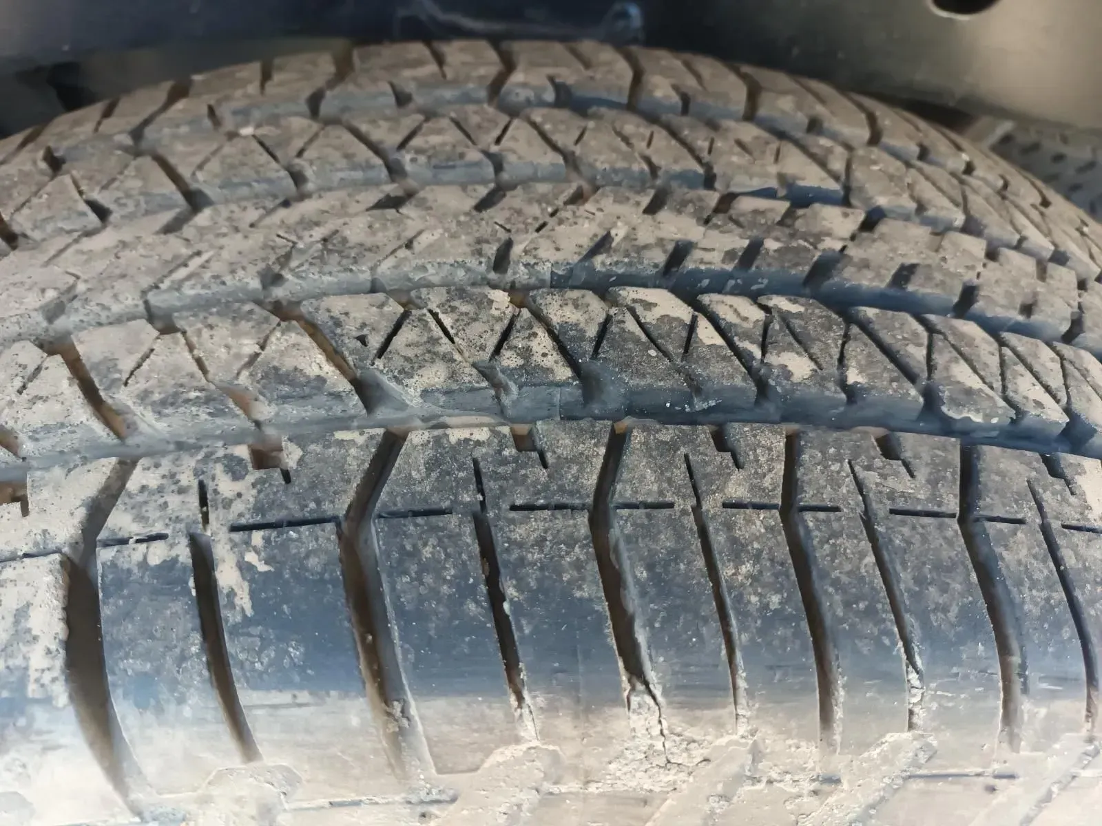 Close-up of a Worn, Dirty Tyre Tread With Deep Grooves and Angled Blocks — South West 4WD Wreckers In Brisbane, QLD