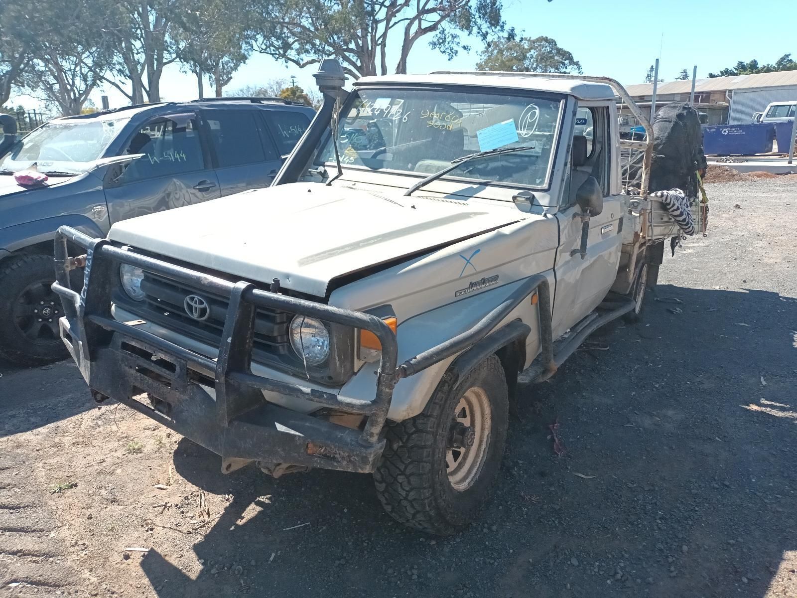A White Toyota Truck is Parked in a Dirt Lot — South West 4WD Wreckers in Harristown, QLD