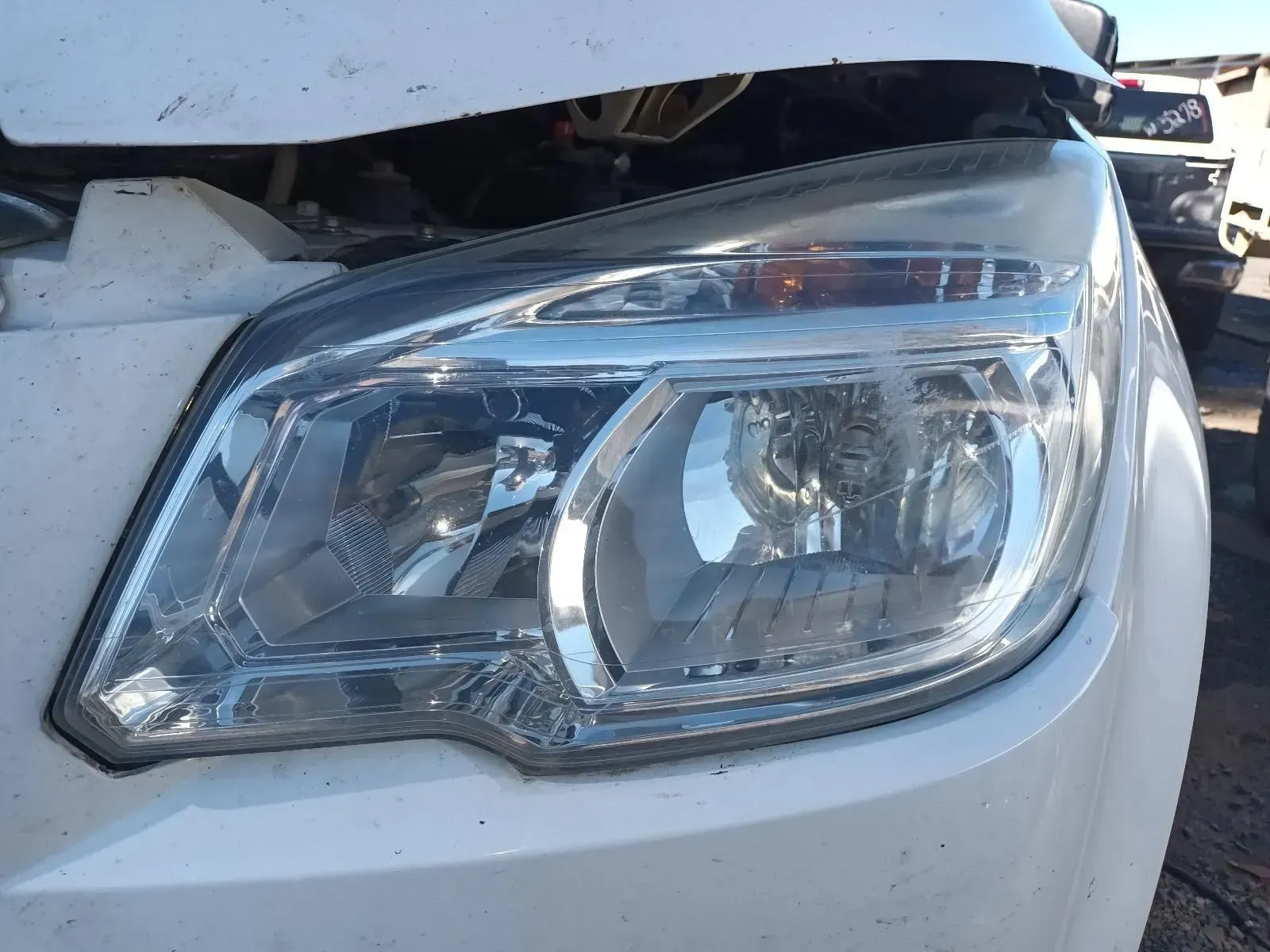Close-up of a White Car's Headlight, Partially Damaged — South West 4WD Wreckers In Brisbane, QLD