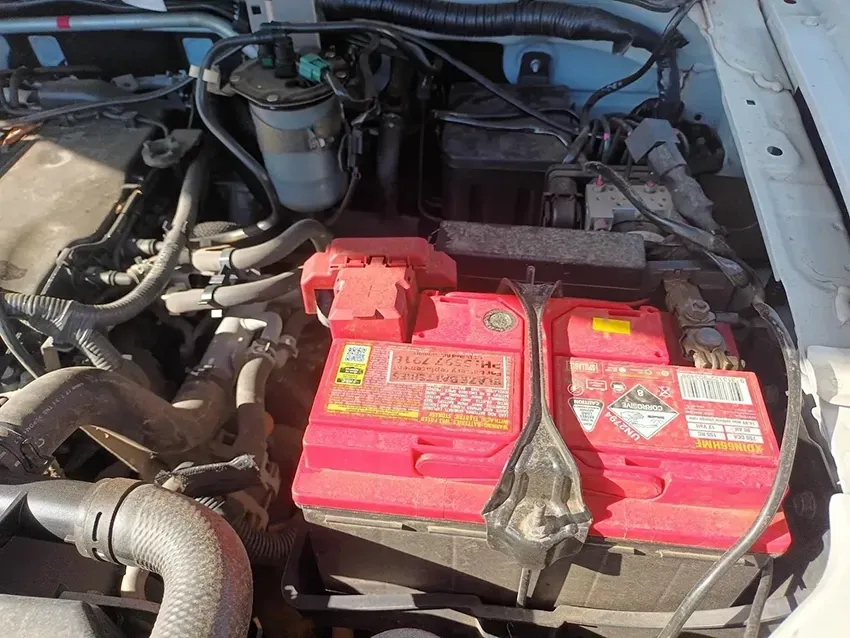 A Red Battery is Sitting Under the Hood of a Car — South West 4WD Wreckers In Brisbane, QLD