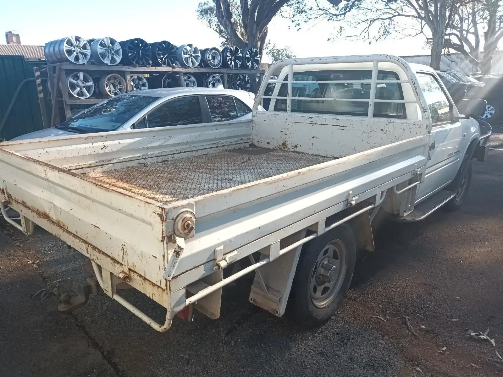 White Pickup Truck With a Flatbed in a Junkyard — South West 4WD Wreckers In Brisbane, QLD