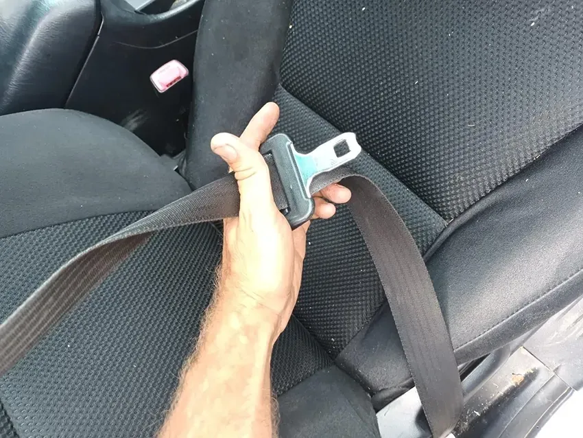 A Person is Putting on a Seat Belt in a Car — South West 4WD Wreckers In Brisbane, QLD