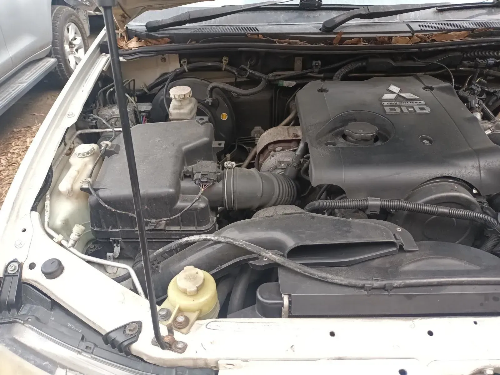 Open Hood of a White Mitsubishi L200 Pickup Truck Showing Engine Components — South West 4WD Wreckers In Brisbane, QLD