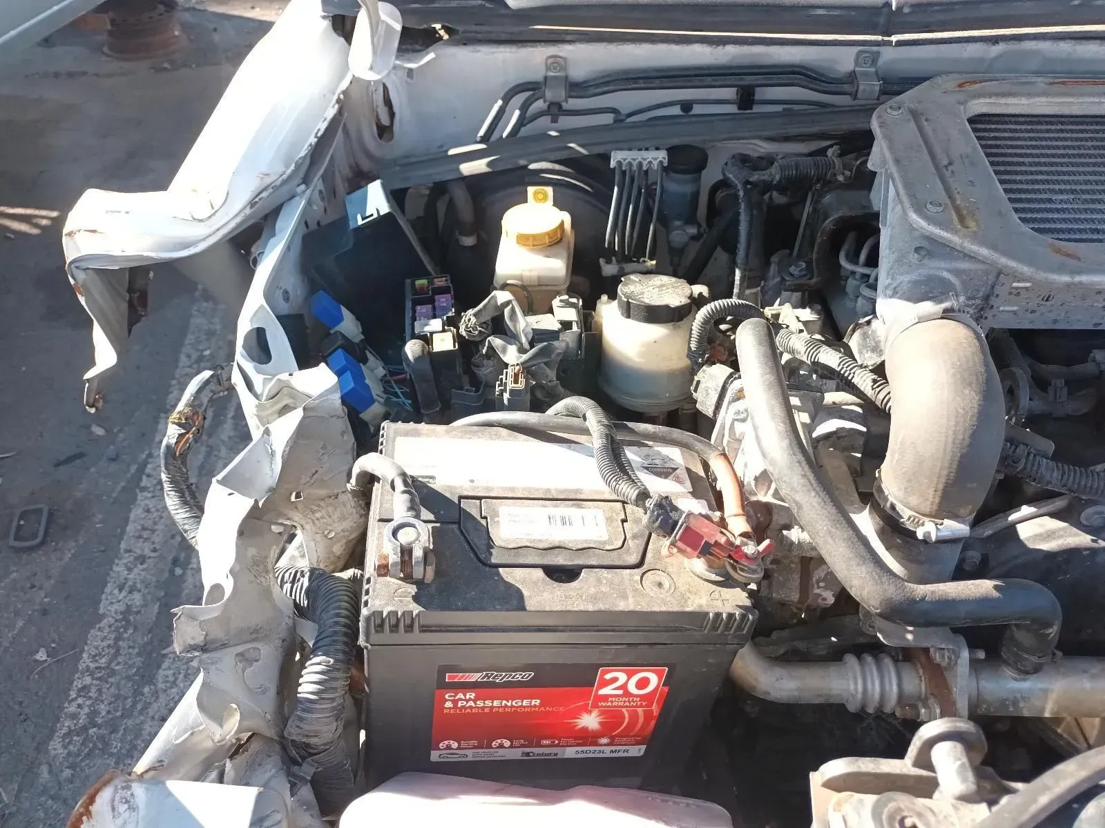 Damaged Car Engine Bay, White Body, Black Battery, Mechanical Components — South West 4WD Wreckers In Brisbane, QLD