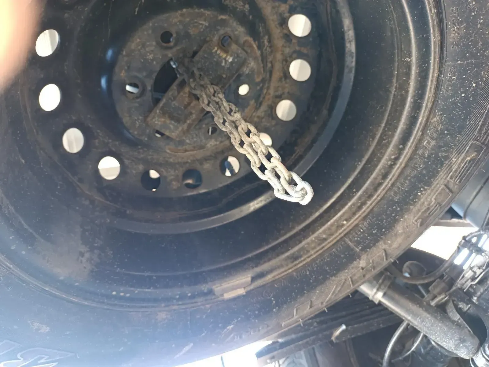 A Spare Tyre on a Car, With a Chain Hanging From the Wheel's Center — South West 4WD Wreckers In Brisbane, QLD