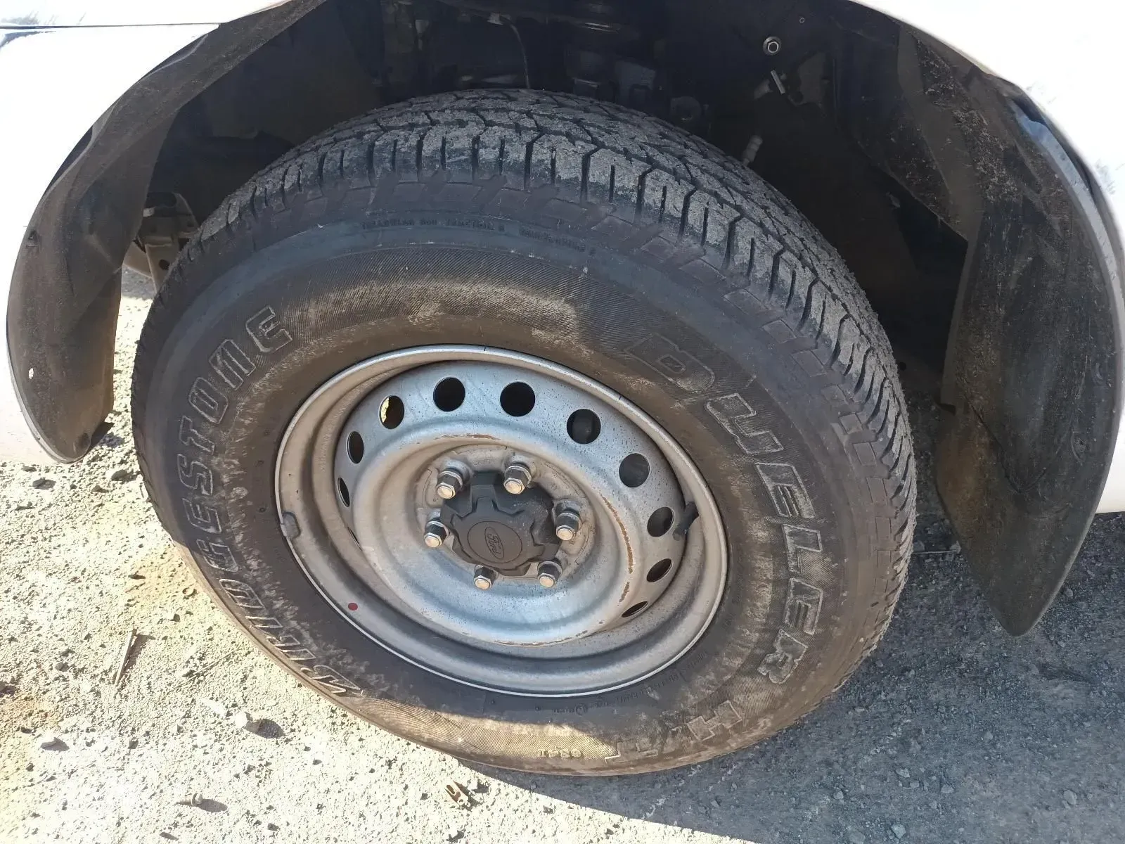 Flat Tyre on a White Vehicle. The Tyre is Deflated and Resting on the Ground — South West 4WD Wreckers In Brisbane, QLD