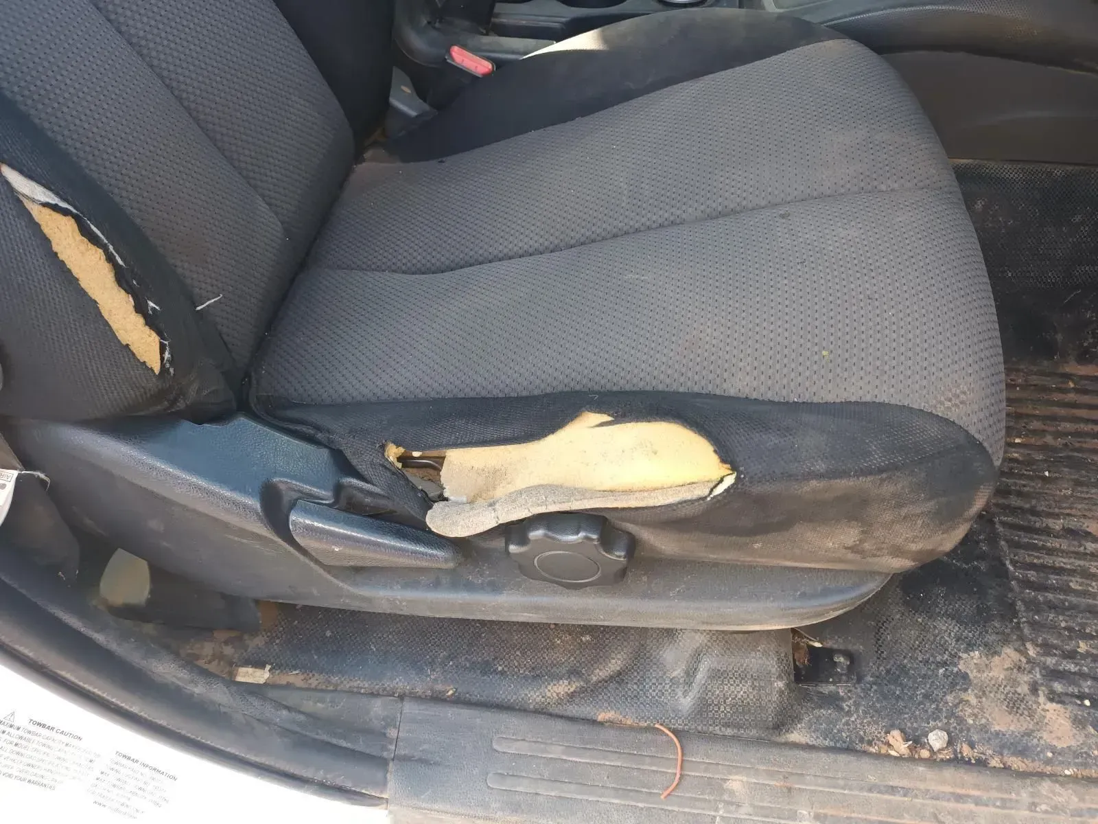 Damaged Gray Car Seat With Torn Fabric; Dirty Floor Visible — South West 4WD Wreckers In Brisbane, QLD
