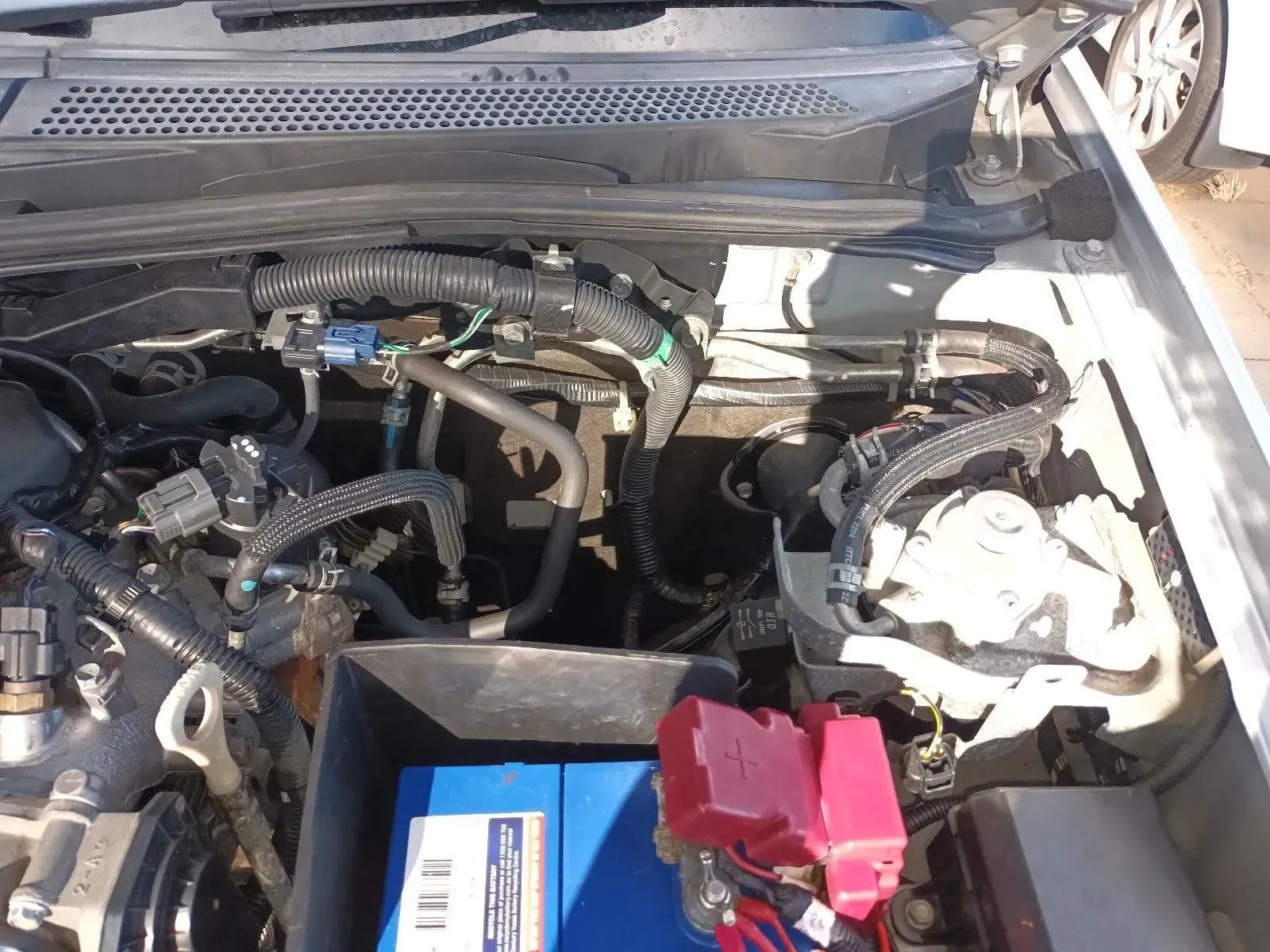 Car Engine Compartment With a Blue Battery and Red Fuse Box — South West 4WD Wreckers In Brisbane, QLD