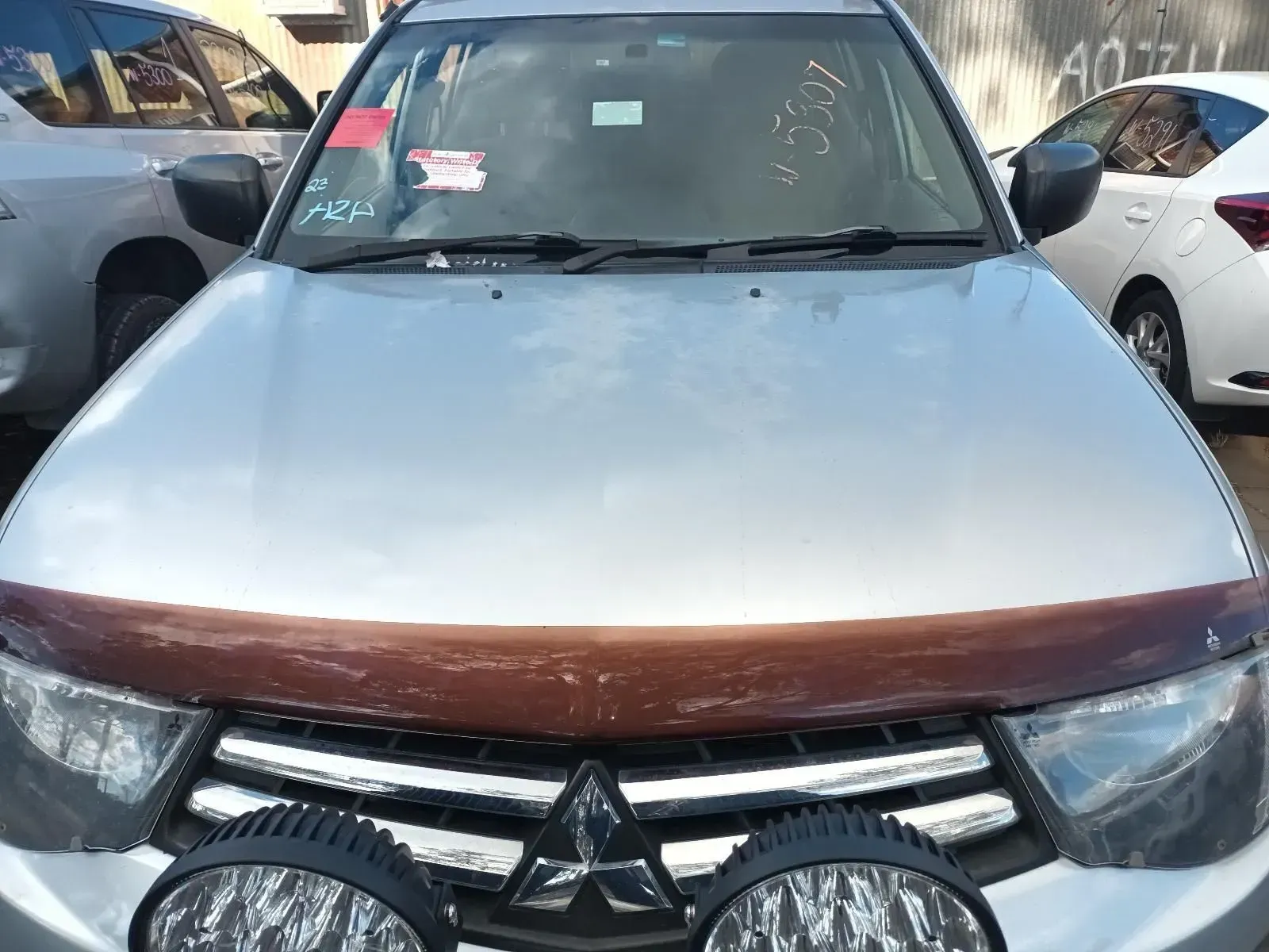 Silver Mitsubishi Truck With a Brown Hood Protector and Auxiliary Lights — South West 4WD Wreckers In Brisbane, QLD