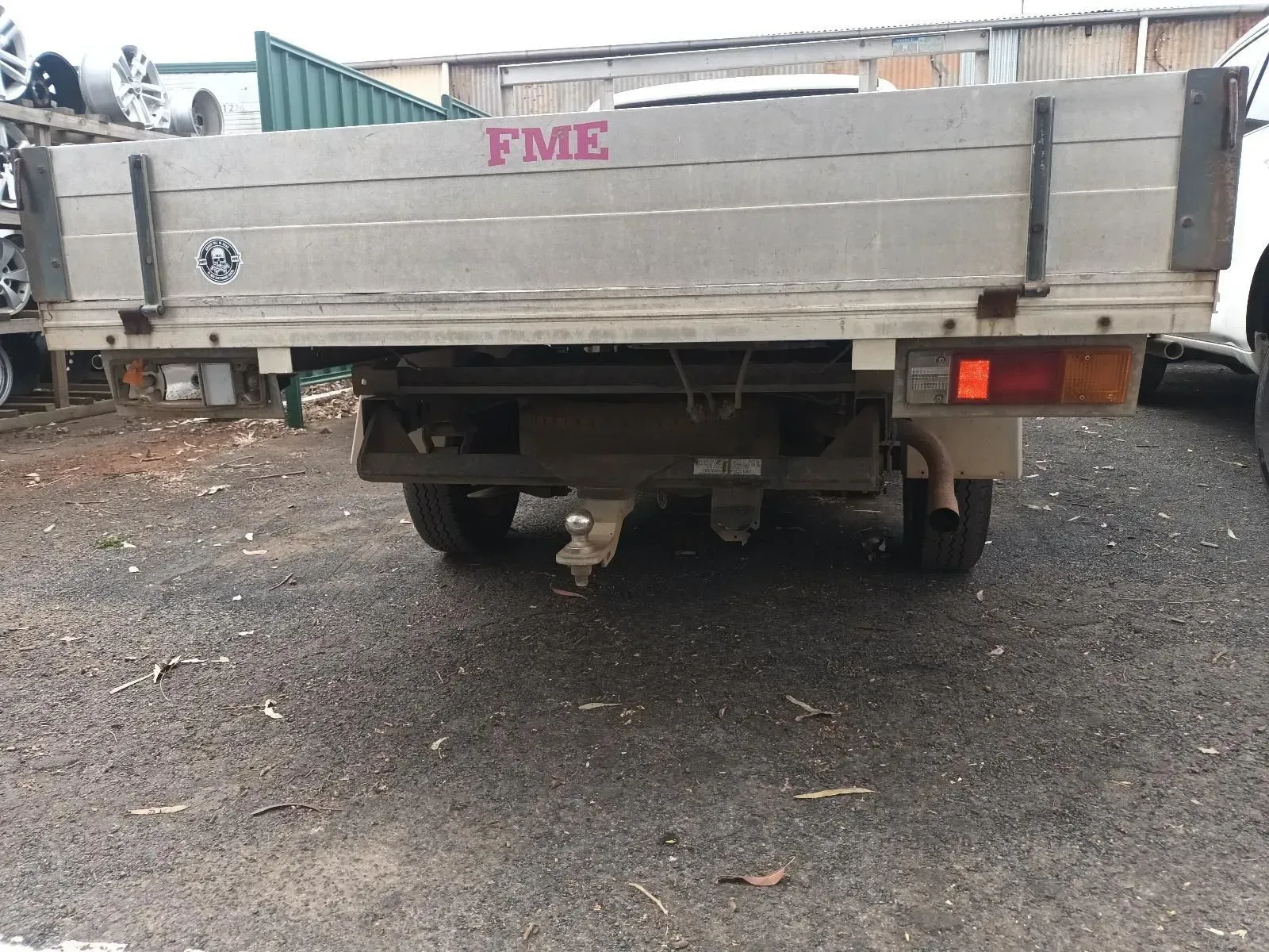 Rear View of a Truck Bed With a Tow Hitch, Fme Logo, and Red Tail Light, Outdoors — South West 4WD Wreckers In Brisbane, QLD
