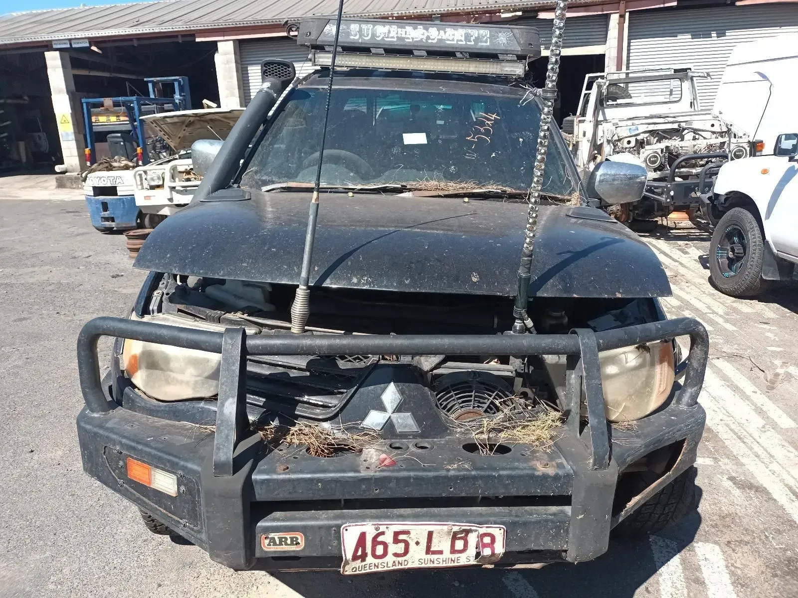 Black Mitsubishi Triton Pickup Truck, Front-end Damaged, in a Junkyard — South West 4WD Wreckers In Brisbane, QLD