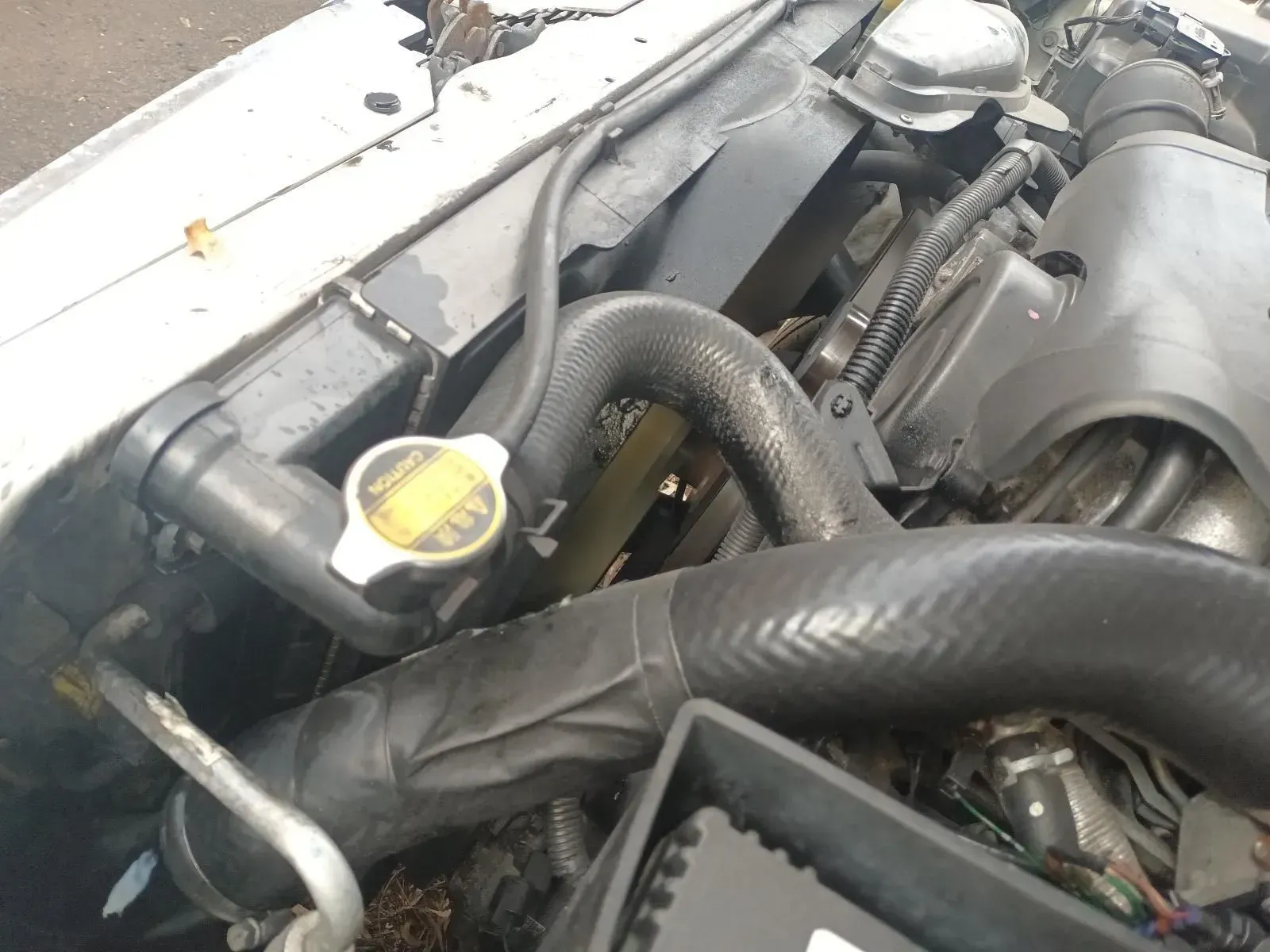Car Engine With Radiator Cap Visible, Black Hoses, and Debris — South West 4WD Wreckers In Brisbane, QLD