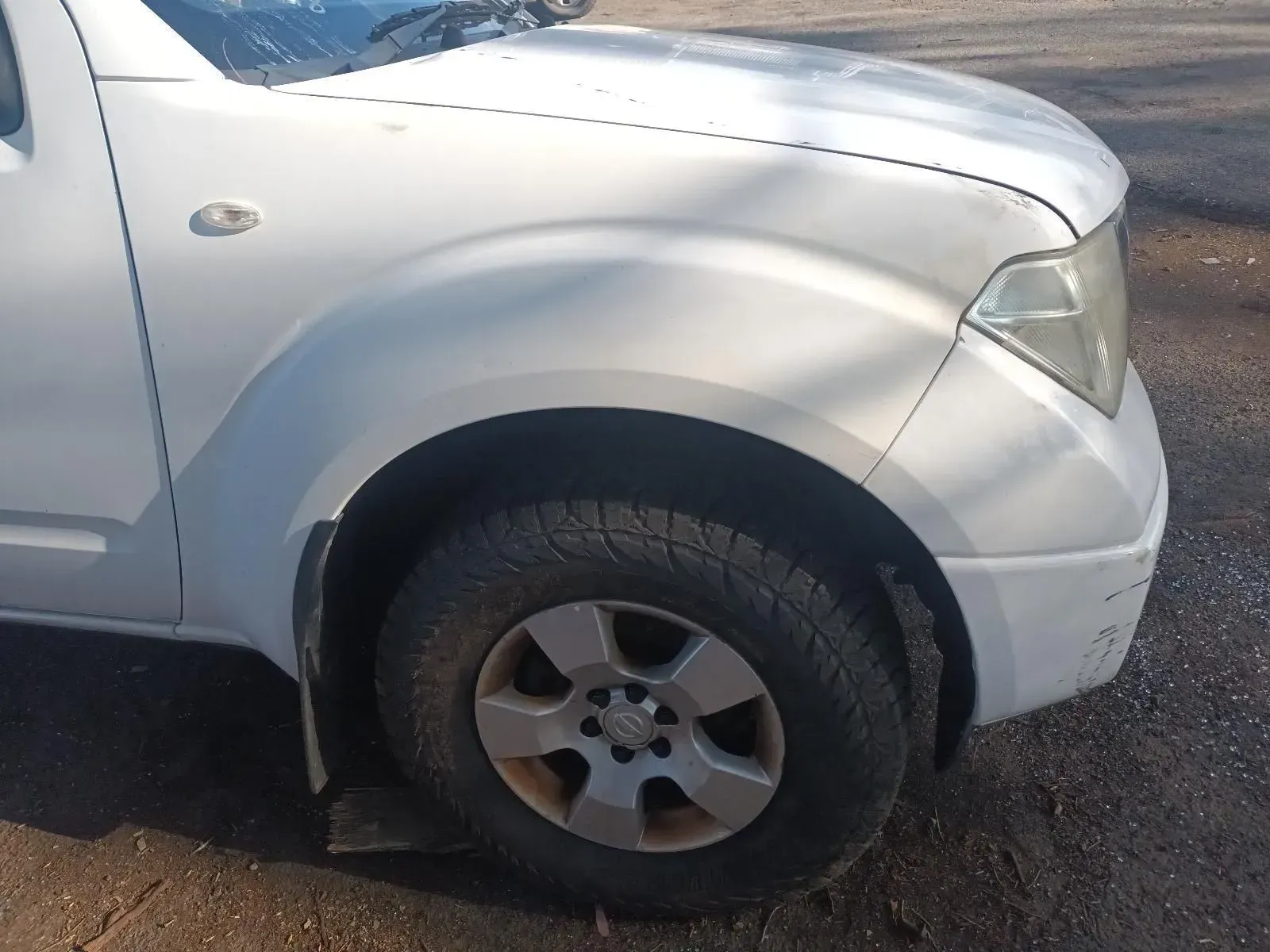 White Pickup Truck's Front Side, Wheel, and Fender, Parked Outdoors — South West 4WD Wreckers In Brisbane, QLD