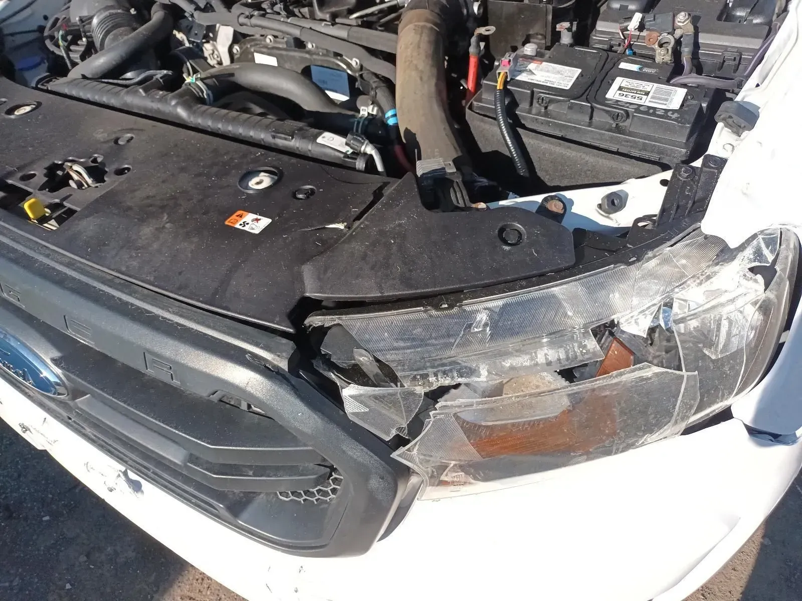 Damaged White Car Headlight and Hood, Showing Collision Damage — South West 4WD Wreckers In Brisbane, QLD