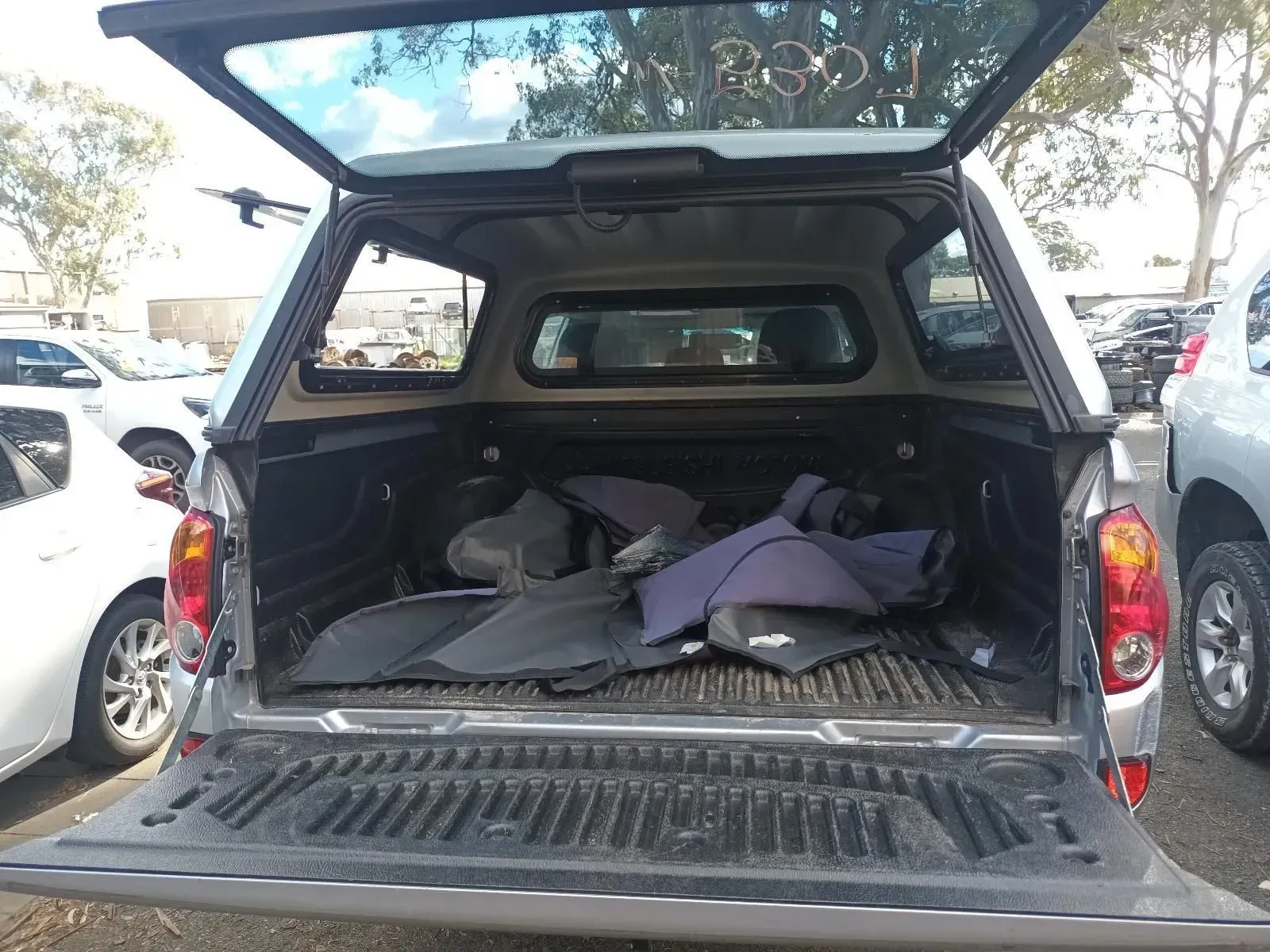 Rear View of a Silver Pickup Truck Bed Open, Filled With Dark Items, Outdoors — South West 4WD Wreckers In Brisbane, QLD