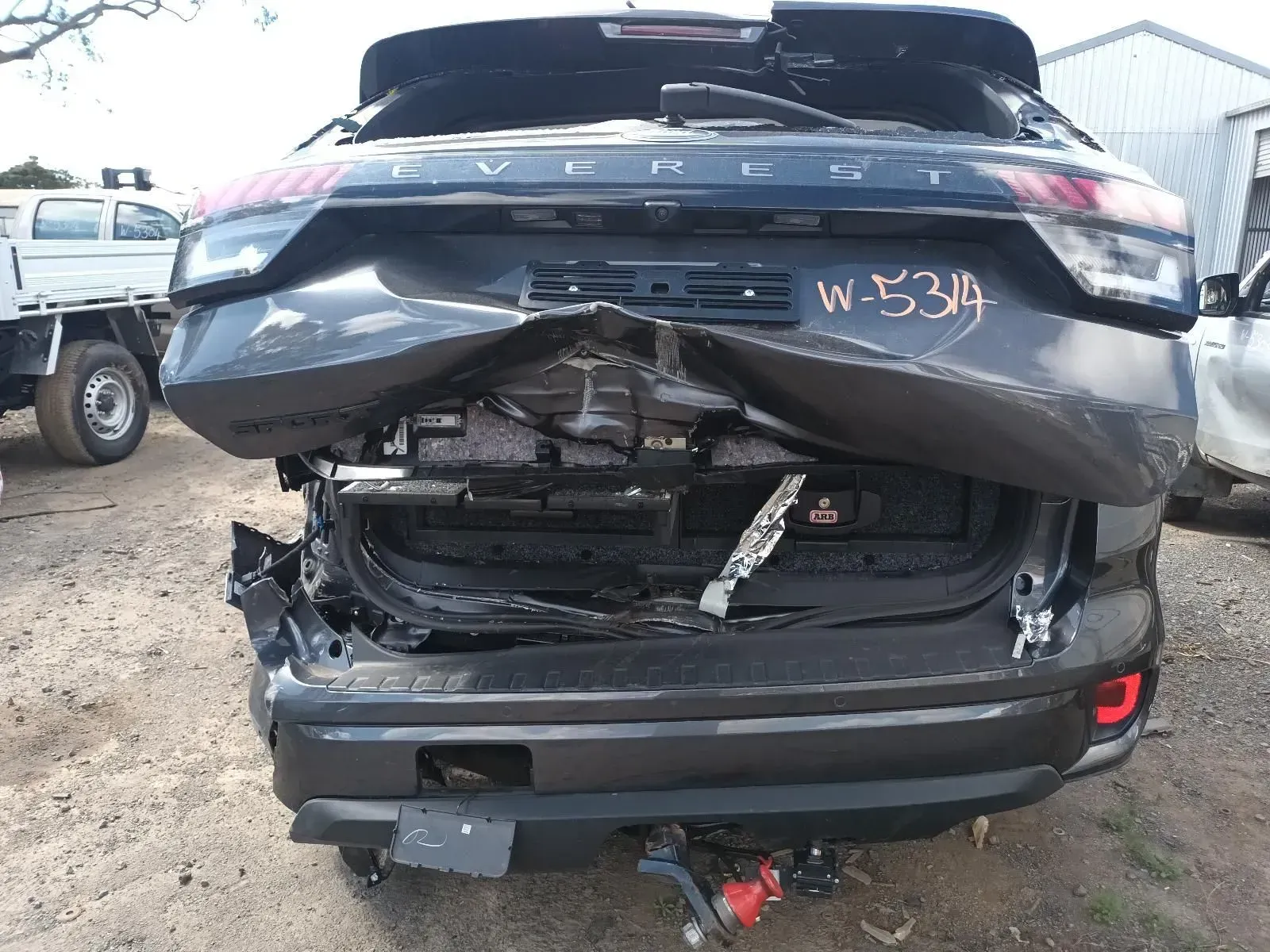 Rear View of a Badly Damaged Black Suv in a Salvage Yard — South West 4WD Wreckers In Brisbane, QLD