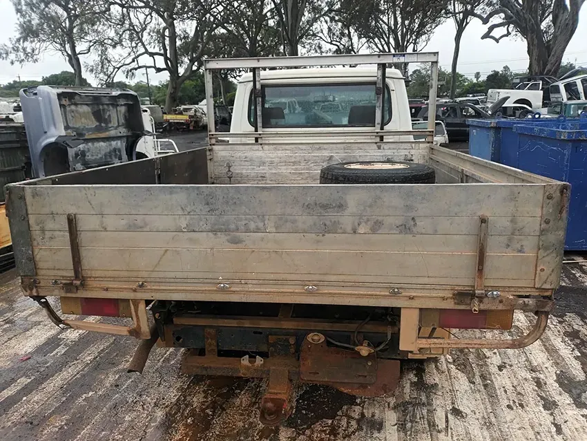 The Back of a Truck With a Flat Bed is Sitting on the Ground — South West 4WD Wreckers In Brisbane, QLD