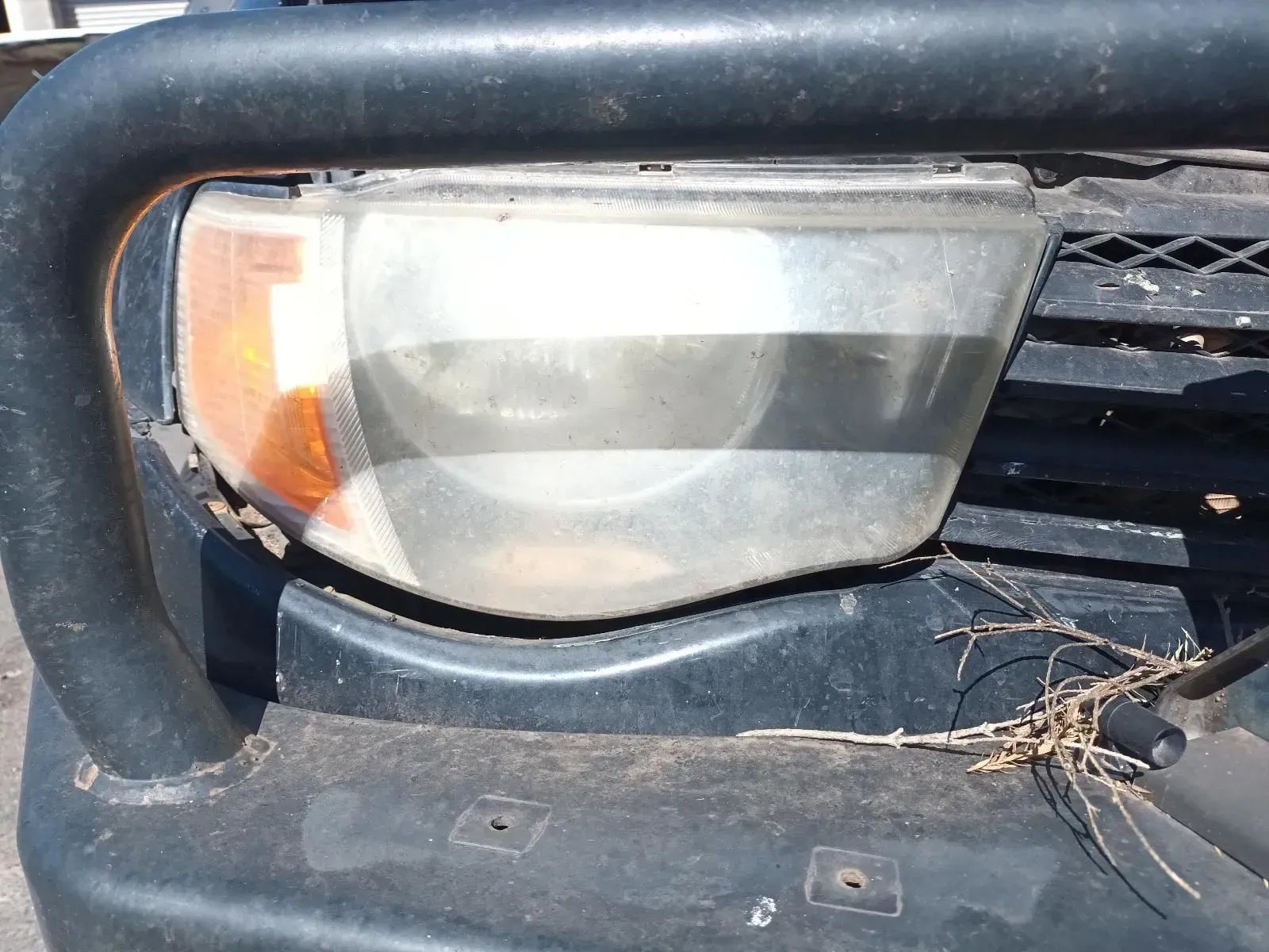Close-up of a Dusty Car Headlight, Next to a Protective Bar — South West 4WD Wreckers In Brisbane, QLD